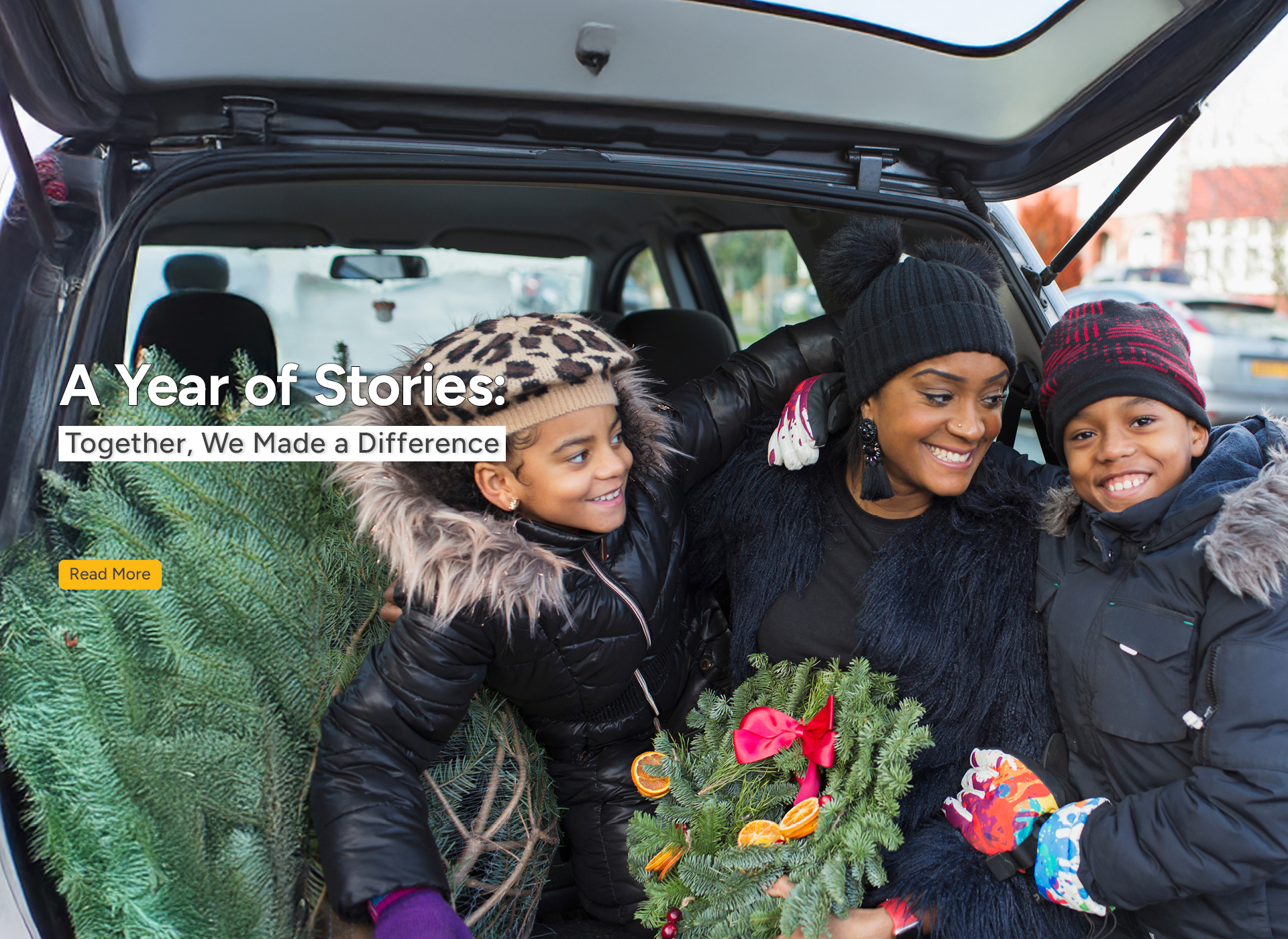 a mom and two kids hold a wreath and get a christmas tree